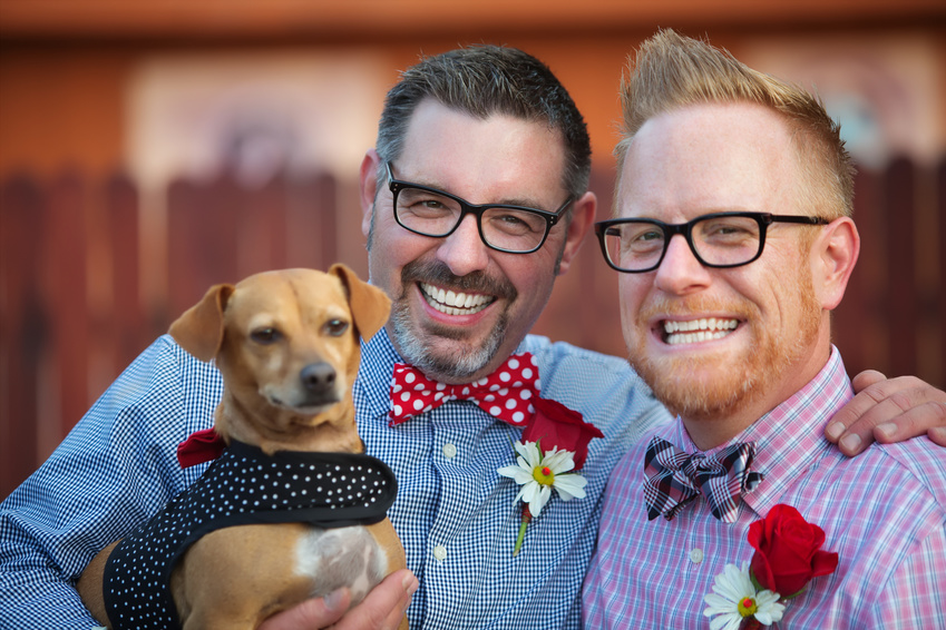 Cheerful married gay couple outdoors with dog